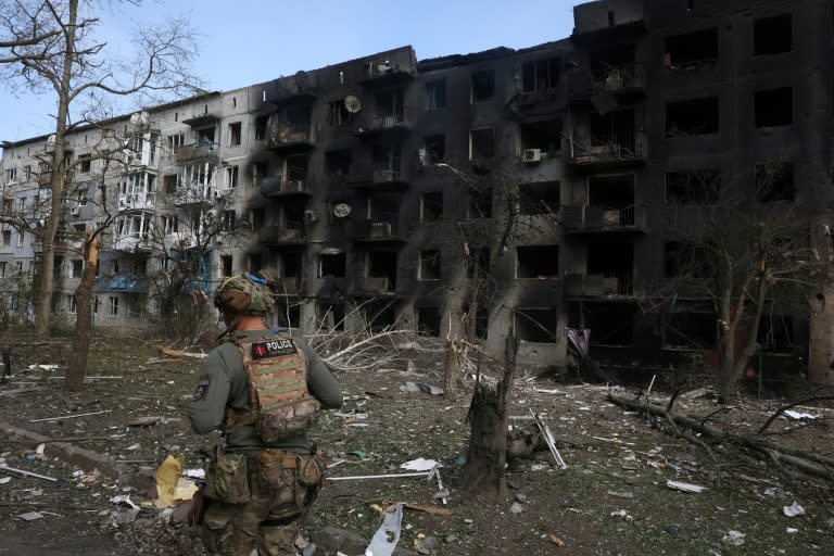 Un policía ucraniano camina frente a un edificio de viviendas destruido en un ataque aéreo y de artillería en el pueblo de Ocheretine, cerca de la ciudad de Avdiivka, el 15 de abril de 2024 al este de Ucrania (Anatolii Stepanov)