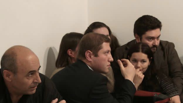 People crouched in the exhibition room after the shooting. Photo: Burhan Ozbilici/AP