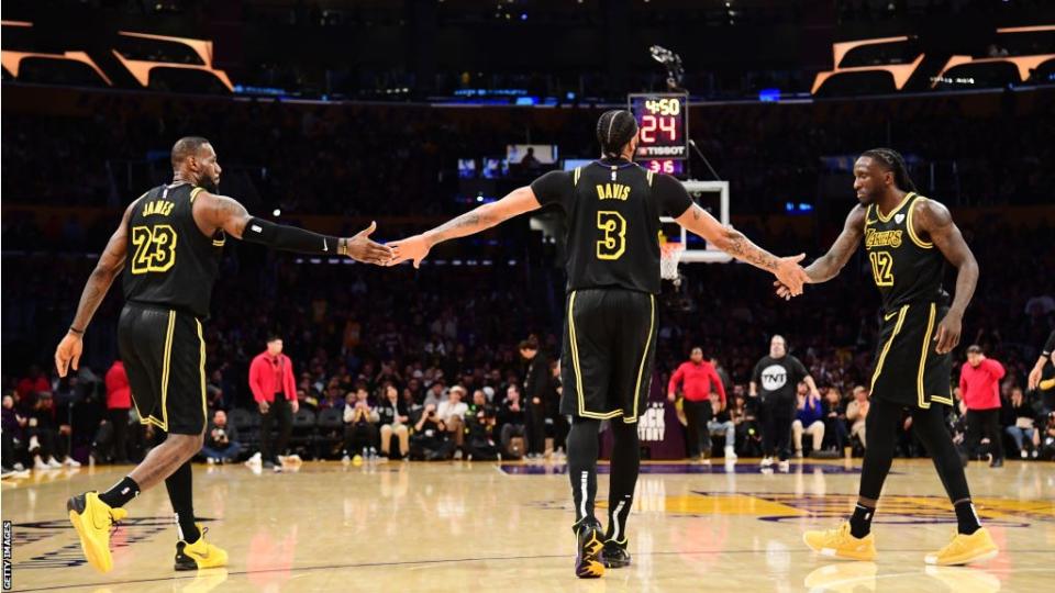 Kobe Bryant, Anthony Davis and Taurean Prince wearing black and yellow 'Black Mamba' jerseys