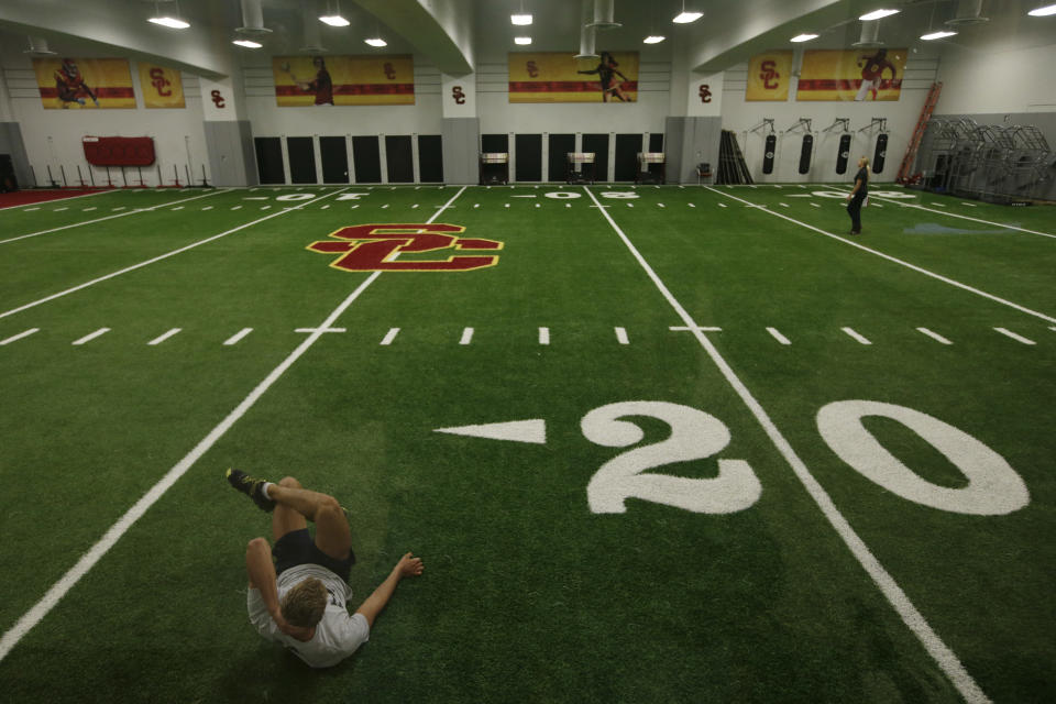 In this Sept. 5, 2013 photo, a student athlete works out on the indoor practice field at the John McKay Center, an athletic facility on the University of Southern California campus  in Los Angeles. Call them football palaces, and no college football program can call itself big-time without one that will leave recruits wide-eyed. (AP Photo/Jae C. Hong)