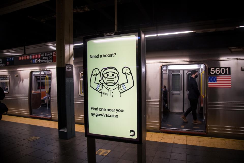 A subway with open doors behind a sign that reads: Need a boost? Find one near you: ny.gov/vaccine