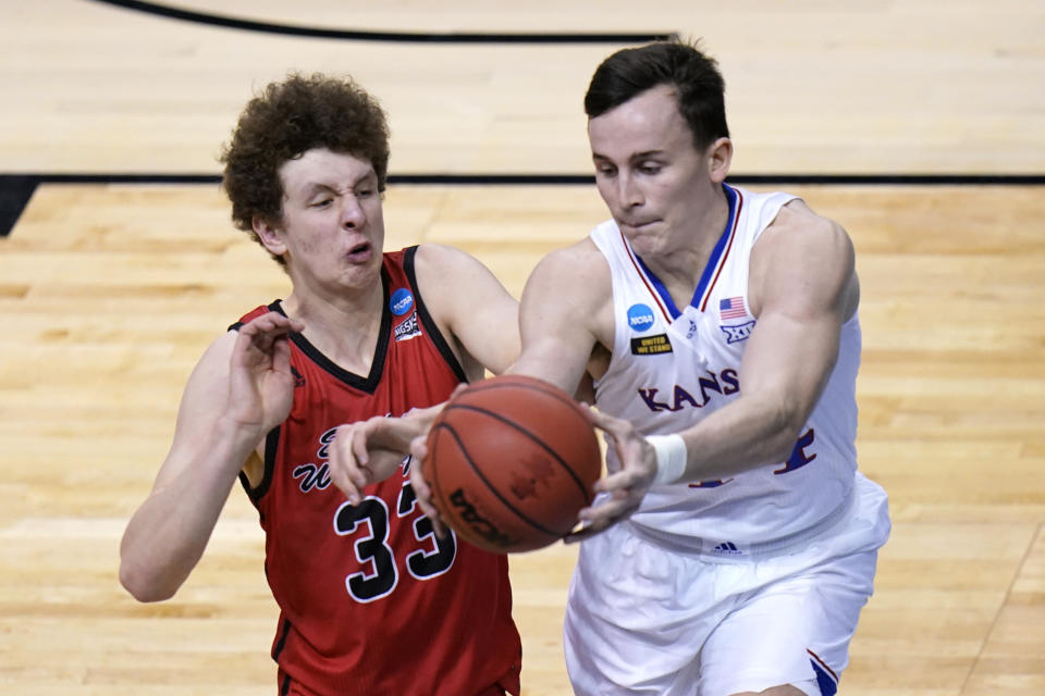 Kansas forward Mitch Lightfoot, left, and Eastern Washington guard Jacob Groves (33) chase a loose ball during the first half of a first-round game in the NCAA college basketball tournament at Farmers Coliseum in Indianapolis, Saturday, March 20, 2021. (AP Photo/AJ Mast)