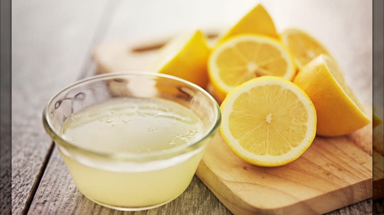 Lemons with bowl of lemon juice