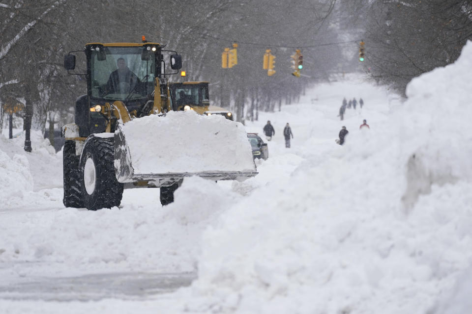 Workers use heavy equipment to clear snow from Richmond Avenue in Buffalo, N.Y., on Monday, Dec. 26, 2022. (Derek Gee/The Buffalo News via AP)