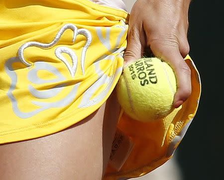 Amandine Hesse of France picks-up a new ball during the women's singles match against Samantha Stosur of Australia during their women's singles match at the French Open tennis tournament at the Roland Garros stadium in Paris, France, May 27, 2015. REUTERS/Vincent Kessler