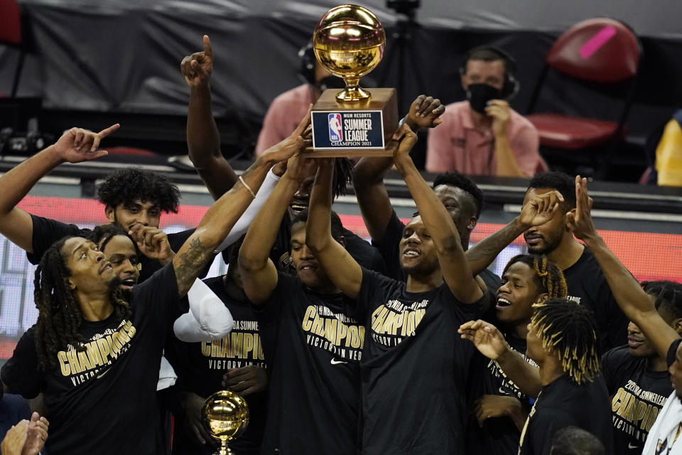 FILE - Sacramento Kings players hold up the trophy after defeating the Boston Celtics in the NBA summer league championship basketball game Tuesday, Aug. 17, 2021, in Las Vegas. NBA Summer League in Las Vegas begins on Thursday, July 7, 2022, with No. 1 pick Paolo Banchero and the Orlando Magic set to play in the first game.(AP Photo/John Locher, File)