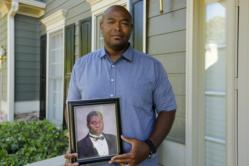 In this Friday, June 14, 2019 photo, Chris Parks poses with a portrait of his brother Donovan Corey Parks in Powder Springs, Ga. Marion Wilson Jr. and Robert Earl Butts Jr. were convicted of murder and sentenced to death in the March 1996 killing of 24-year-old Donovan Corey Parks. Butts was executed in May 2018. Wilson, who’s 42, is set for execution Thursday, June 20. (AP Photo/Andrea Smith)