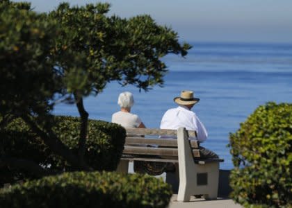 An elderly couple looks out at the ocean as they sit on a park bench in La Jolla, California November 13, 2013.  REUTERS/Mike Blake