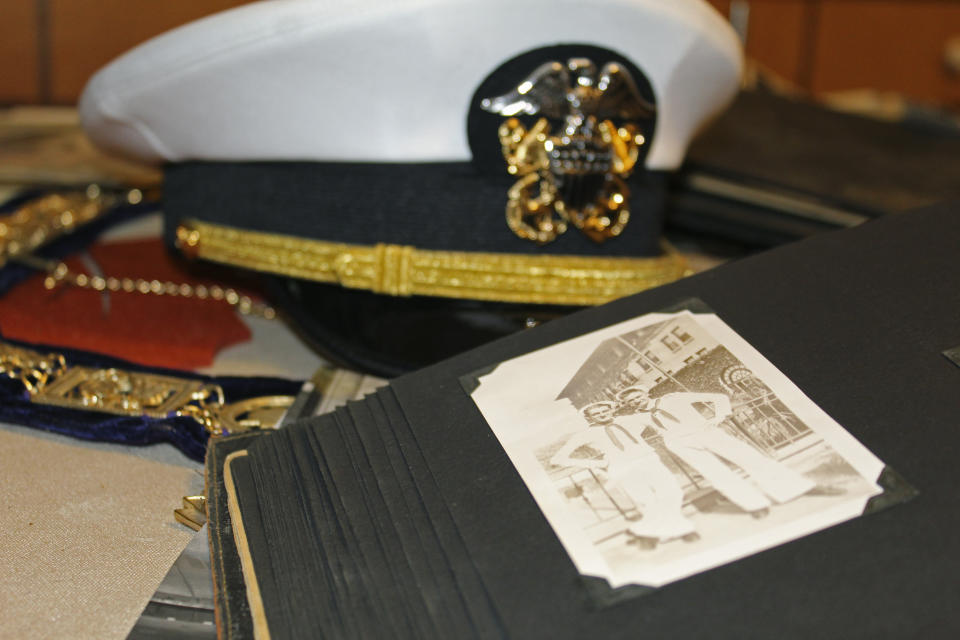 A white U.S. Navy cap, Navy memorabilia and old photographs are displayed on the kitchen table of Pearl Harbor survivor Ira "Ike" Schab, 103, at his home in Beaverton, Ore. on Monday, Nov. 20, 2023. Schab was in the Navy and on the USS Dobbin during the Pearl Harbor attacks on Dec. 7, 1941. Eighty-two years later, Schab plans to return to Pearl Harbor on the anniversary of the attack to remember the more than 2,300 servicemen killed. (AP Photo/Claire Rush)