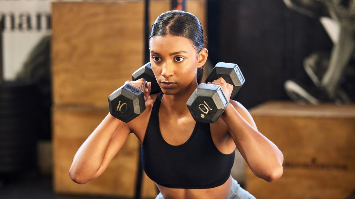  A photo of a woman holding two dumbbells. 