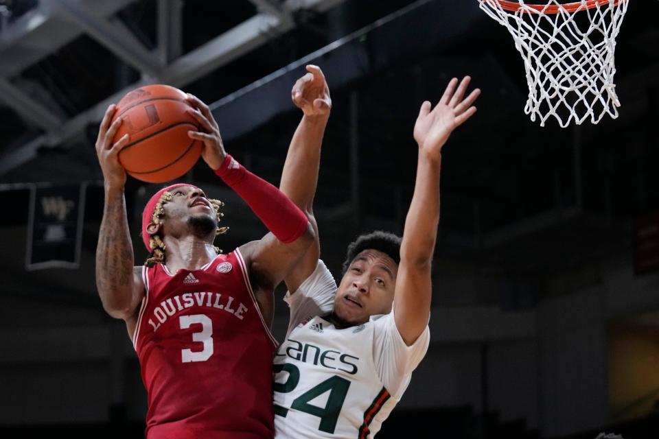 Louisville guard El Ellis (3) goes up for a shot against Miami guard Nijel Pack (24) during the second half of an NCAA college basketball game, Saturday, Feb. 11, 2023, in Coral Gables, Fla. (AP Photo/Wilfredo Lee)