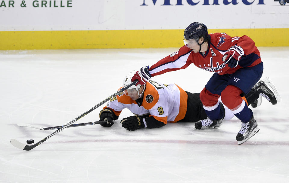 Washington Capitals center Nicklas Backstrom (19), of Sweden, reaches for the puck against Philadelphia Flyers defenseman Ivan Provorov (9), of Russia, during the third period of an NHL hockey game, Sunday, Jan. 15, 2017, in Washington. (AP Photo/Nick Wass)