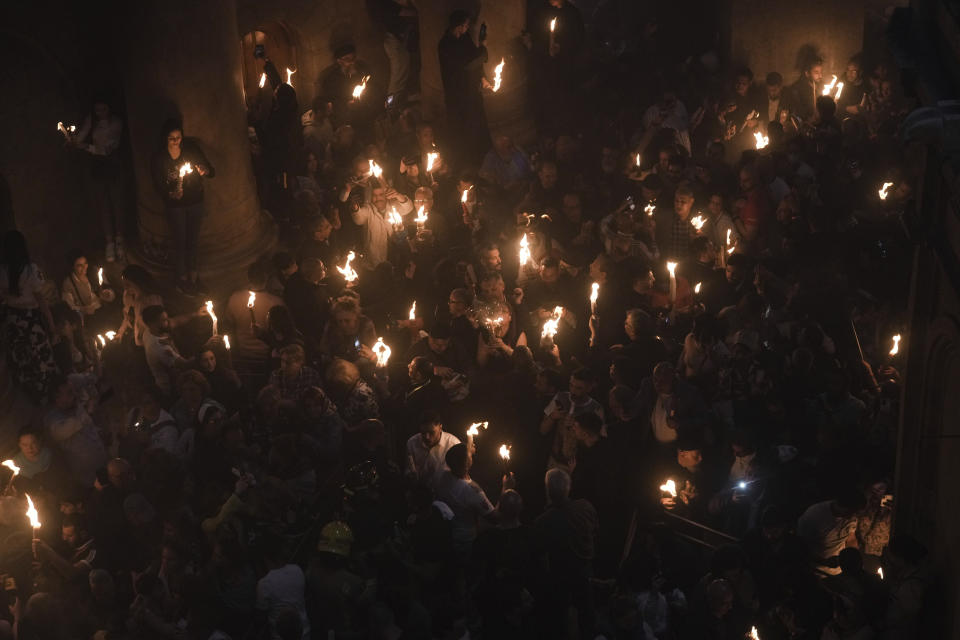 Christians pilgrims hold candles during the Holy Fire ceremony, a day before Easter, at the Church of the Holy Sepulcher, where many Christians believe Jesus was crucified, buried and resurrected, in Jerusalem's Old City, Saturday, April 15, 2023. (AP Photo/Mahmoud Illean)