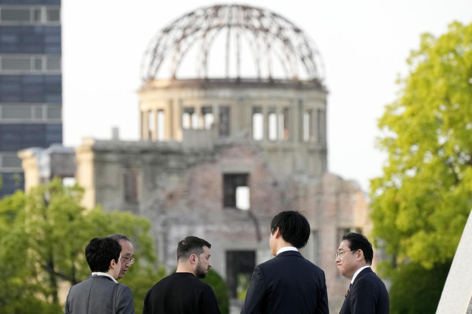 Ukrainian President Volodymyr Zelenskyy, third left, and Japanese Prime Minister Fumio Kishida, right, have a talk after laying flowers in front of the Cenotaph for the Victims of the Atomic Bomb at the Hiroshima Peace Memorial Park after he was invited to the Group of Seven (G7) nations' summit in Hiroshima, western Japan Sunday, May 21, 2023. The Atomic Bomb Dome is seen in the background. (AP Photo/Eugene Hoshiko, Pool)