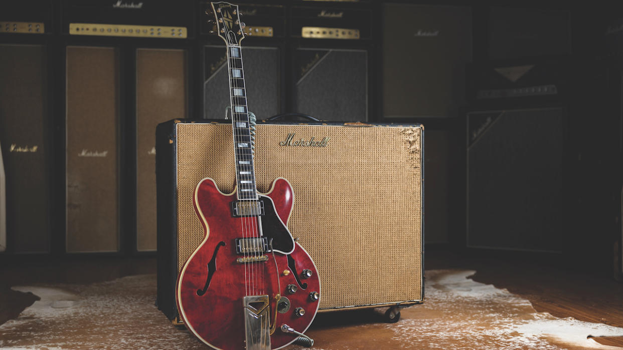  A 1962 Gibson ES-355 guitar sitting in front of a Marshall amplifier. 