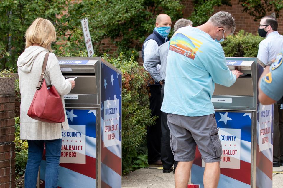 Voters insert their mail-in ballots into drop boxes outside the Bucks County Administration Building in Doylestown Borough on Monday, October 19, 2020.