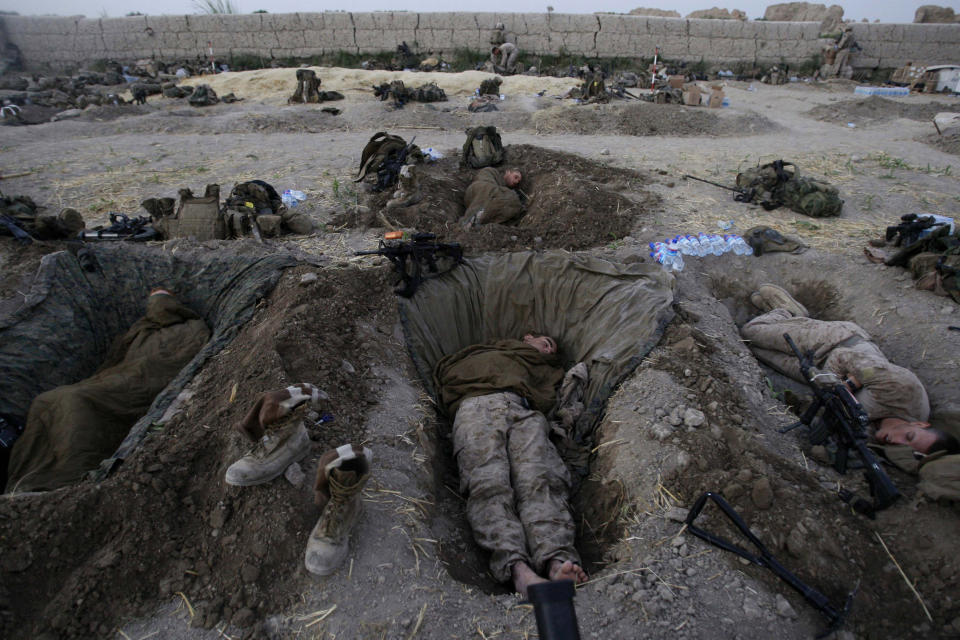 U.S. Marines from the 2nd MEB, 1st Battalion 5th Marines sleep in their fighting holes inside a compound where they stayed for the night, in the Nawa district of Afghanistan's Helmand province, on July 8, 2009. (AP Photo/David Guttenfelder, File)