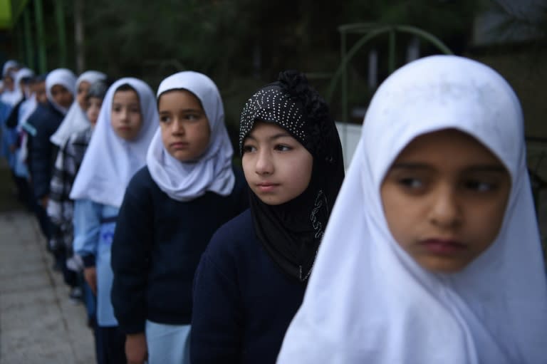 Dunya (2nd R) and her classmates are returning to school after more than two-months of holiday