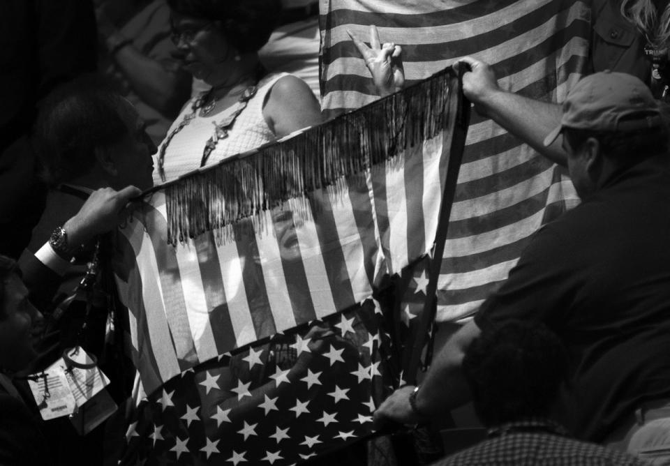 <p>A protestor is blocked from the cameras by convention goers using American flag banners at the Republican National Convention Tuesday, July 19, 2016, in Cleveland, OH. She was advocating “No Racism, No Hate”. (Photo: Khue Bui for Yahoo News.</p>