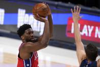 Philadelphia 76ers center Joel Embiid (21) takes a shot over Dallas Mavericks forward Maxi Kleber, right, in the second half of an NBA basketball game in Dallas, Monday, April 12, 2021. (AP Photo/Tony Gutierrez)