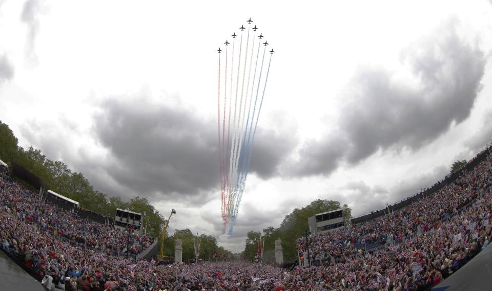 Royal Air force Red Arrow display team fly pass Buckingham Palace in London where Britain Queen Elizabeth II watches from the palace balcony as part of a four-day Diamond Jubilee celebration to mark the 60th anniversary of Queen Elizabeth II accession to the throne, Tuesday, June 5, 2012. (AP Photo/Sang Tan)