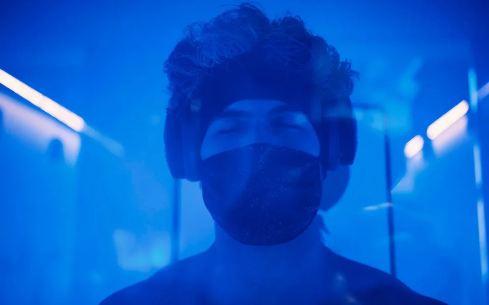 A young adult man in a cryotherapy chamber in a biohacking lab