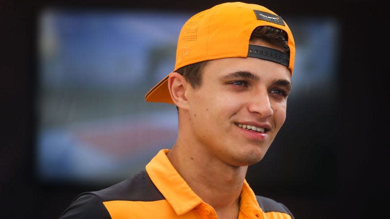 A photo of Lando Norris wearing an orange cap backwards. 