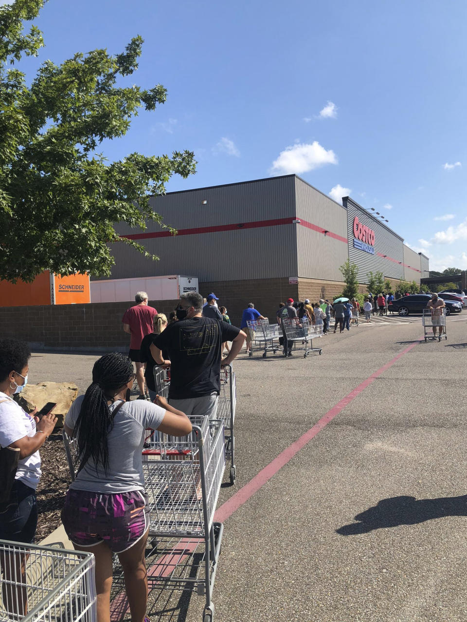 In a photo provided by John Snow, people line up to enter a Costco store Sunday, Aug. 23, 2020, in Baton Rouge, La., as Hurricane Marco was moving toward Louisiana. (John Snow via AP)