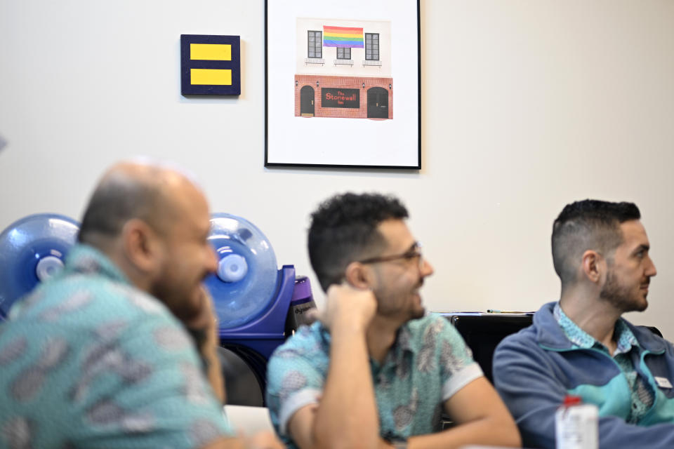 Artwork is displayed on a wall during a staff meeting of the Pineapple Healthcare medical clinic in Orlando, Fla., on May 28, 2024. (AP Photo/Phelan M. Ebenhack)