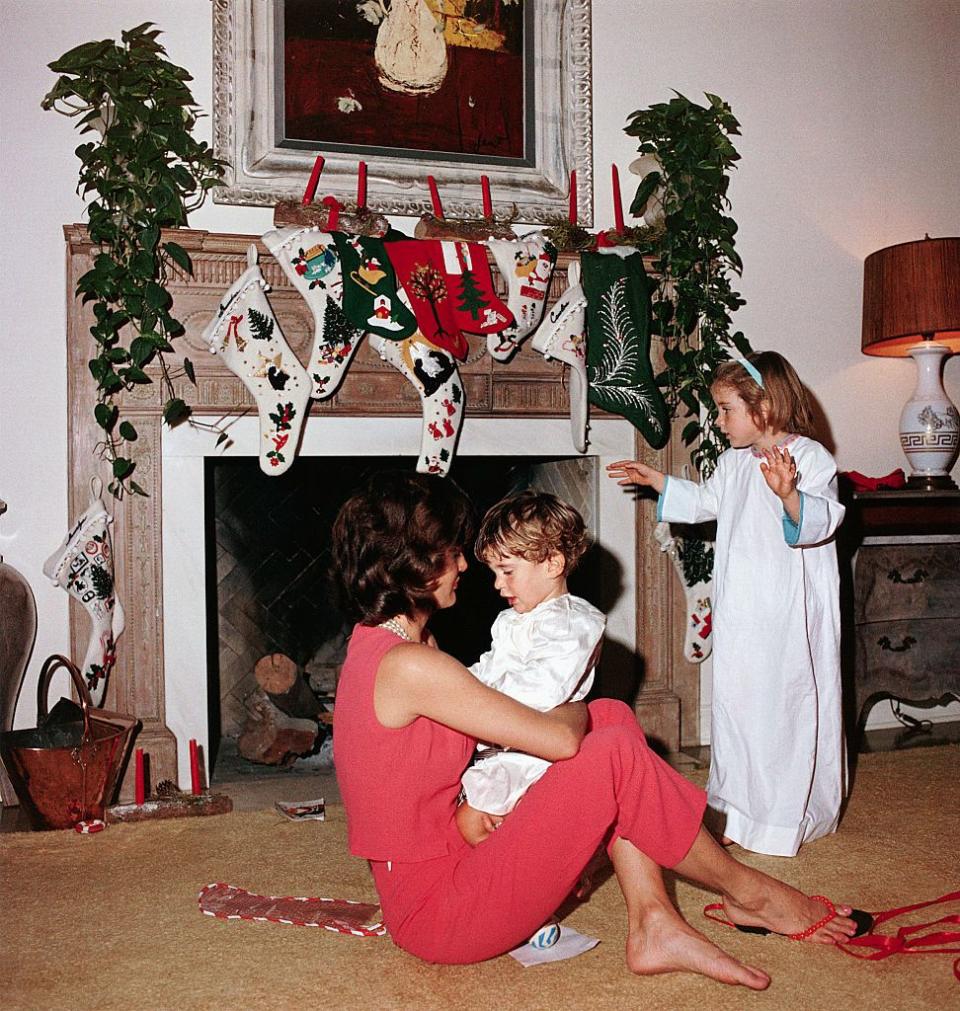 <p>Here, on Christmas Day in 1962, Jackie O. looks fantastically relaxed, barefoot on the floor consoling John, Jr. We love this sweet snapshot of this special day that the family celebrated with another beloved style icon, Lee Radziwill; her husband, Anthony; and their daughter, Ann.</p>