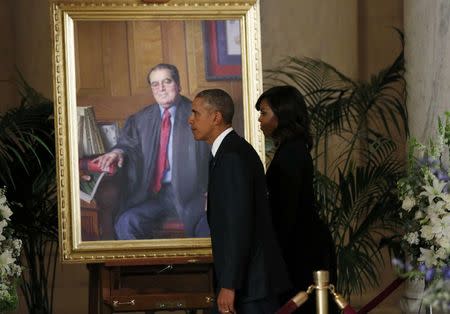 U.S. President Barack Obama and first lady Michelle Obama walk past a portrait of U.S. Supreme Court Justice Antonin Scalia after paying their respects at his casket in the U.S Supreme Court's Great Hall in Washington February 19, 2016. Scalia died on February 13, 2016 at the age of 79. REUTERS/Kevin Lamarque