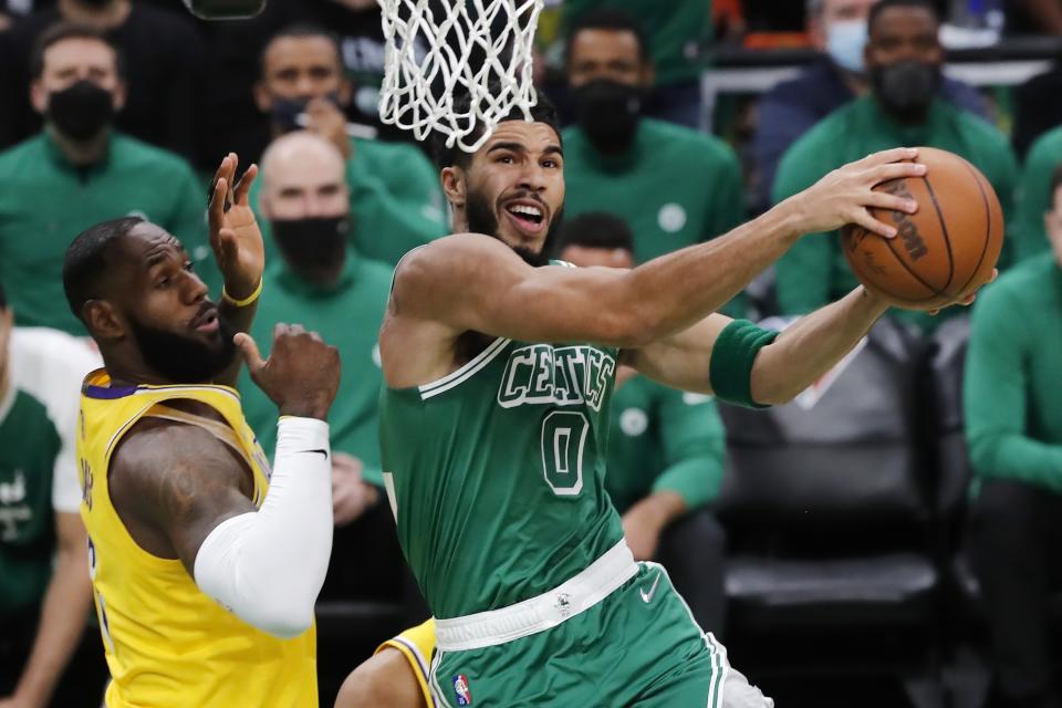 Boston Celtics' Jayson Tatum (0) goes up to shoot against Los Angeles Lakers' LeBron James, left, during the first half of an NBA basketball game, Friday, Nov. 19, 2021, in Boston. (AP Photo/Michael Dwyer)