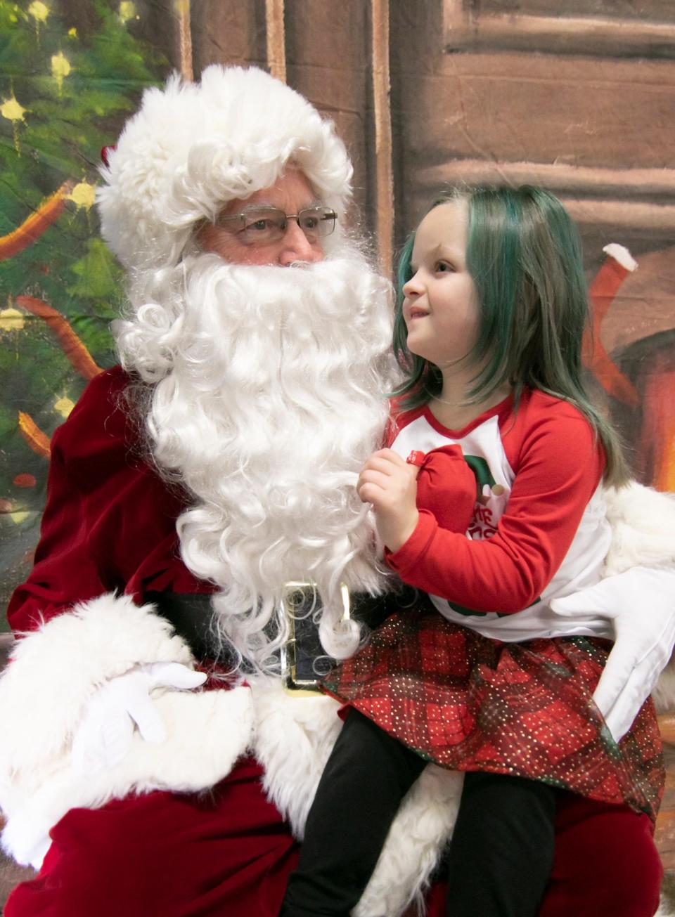 5-year-old Klaryssa Holbrook tells Santa what's on her Christmas list in the Fowlerville Fire Station during Christmas in the Ville Saturday, Dec. 4, 2021.