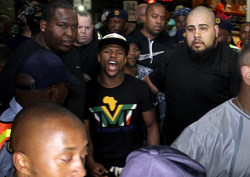 Boxer Floyd Mayweather Jr, center, on his arrival in Johannesburg Wednesday Jan 15, 2014. Mayweather Jr. is in the country for a six-day visit that the government hopes will help "resuscitate" boxing in the country. (AP Photo)