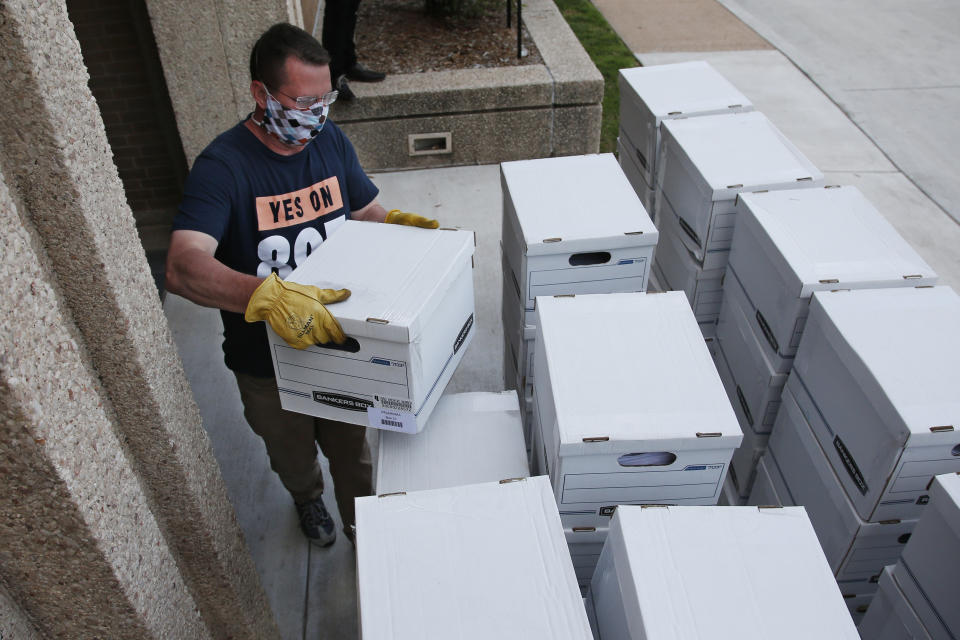 FILE - In this Monday, June 1, 2020 file photo, Kris Steele, Executive Director of OCJR and TEEM, carries a box of petitions as Yes on 805 delivers 260,000 gathered signatures to the Secretary of State's office in Oklahoma City, to put sentencing reform on a 2020 ballot. Oklahoma voters will vote in Tuesday's primary election on State Question 802, which would amend the Oklahoma Constitution to expand Medicaid health insurance. (AP Photo/Sue Ogrocki, Pool, File)