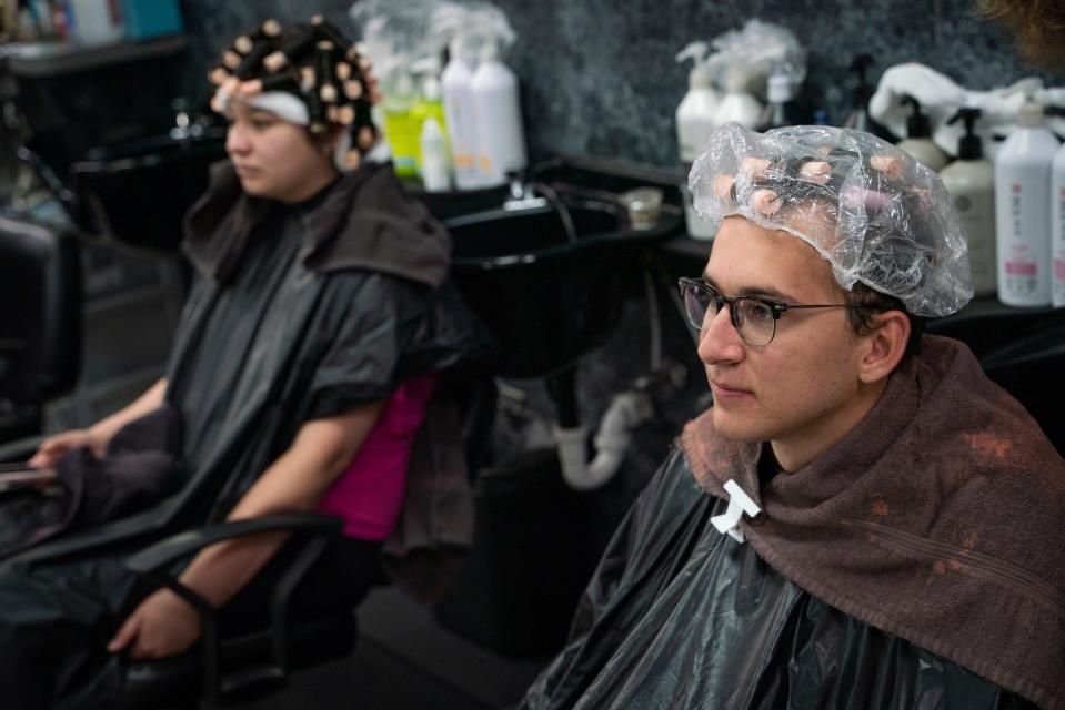 Emilie Nieves, 19, of Allen Park, left, and Owen Terechenok, 21, of Canton, wait for their perms to finish processing at Anthony's Hair Inc in Allen Park on July 25, 2023.