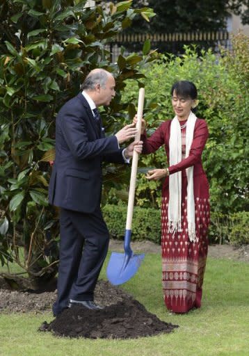 France's Foreign Minister Laurent Fabius (L) gives a shovel to Myanmar pro-democracy leader Aung San Suu Kyi to plant the tree of Freedom in the garden of the Foreign Affairs Ministry in Paris. Myanmar's democracy champion Aung San Suu Kyi, nearing the end of her triumphant Europe tour in France, accepted another award Wednesday as she became an honorary citizen of Paris