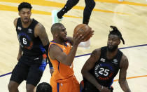 Phoenix Suns guard Chris Paul (3) drives between New York Knicks guard Elfrid Payton (6) and forward Reggie Bullock (25) during the first half of an NBA basketball game Friday, May 7, 2021, in Phoenix. (AP Photo/Rick Scuteri)