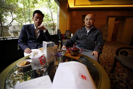 A paper with the verdict in the trial of Chinese rights activist Xu Zhiyong is seen on a table as Xu's lawyers Zhang Qingfang (R) and Liu Shuqing speak to journalists at a hotel in Beijing, April 11, 2014. REUTERS/Petar Kujundzic