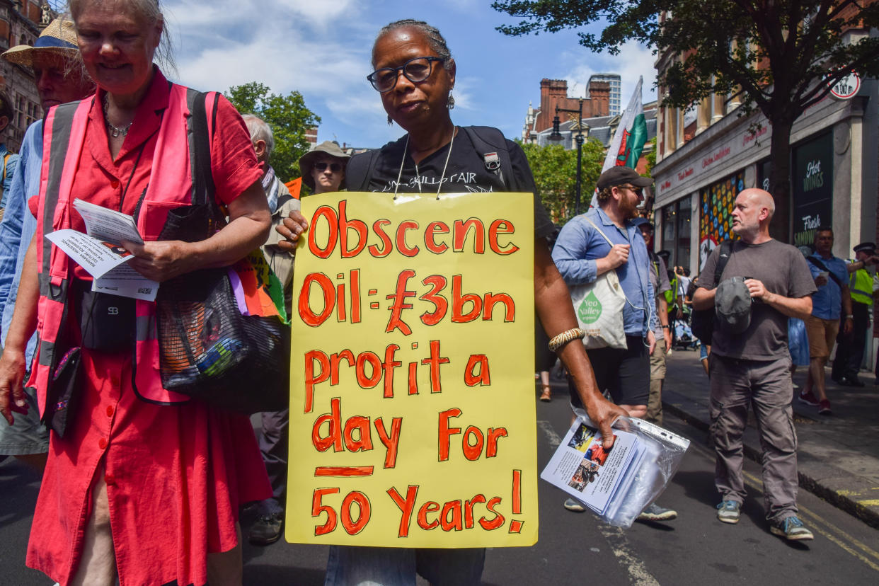 LONDON, UNITED KINGDOM - 2022/07/23: A protester holds a placard stating that oil companies have been making a profit of £3 billion per day for 50 years, during the demonstration in Bloomsbury. Protesters from Just Stop Oil, Extinction Rebellion, Insulate Britain and other groups marched through central London calling on the government to end fossil fuels, tax big polluters and billionaires, provide insulation for all homes, and act on the climate and cost of living crisis. (Photo by Vuk Valcic/SOPA Images/LightRocket via Getty Images)