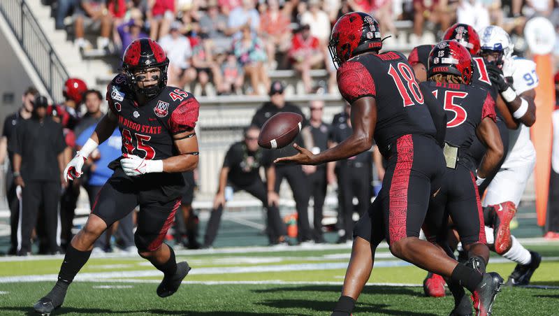 San Diego State quarterback Jalen Mayden (18) tosses the ball to wide receiver Jesse Matthews (45) during the first half of the Hawaii Bowl NCAA college football game, Saturday, Dec. 24, 2022, in Honolulu. 