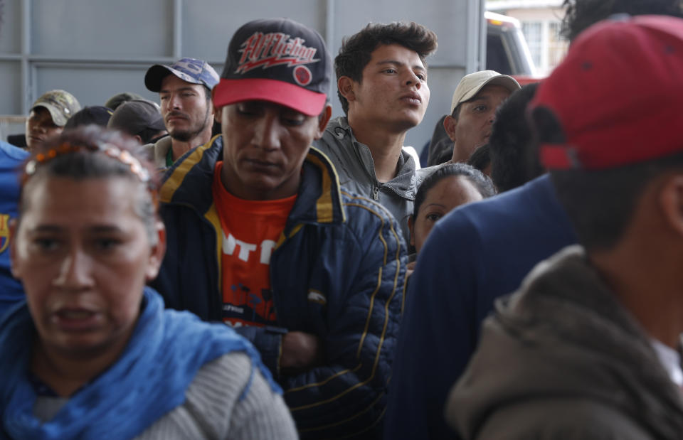 In this Dec. 4, 2018 photo, Central American migrants wait in line at a job fair where they are able to apply for Mexican work permits, recover lost Honduran identity documents and meet with potential employers in Tijuana, Mexico. Mexican authorities have encouraged all of the migrants to regularize their status in Mexico and seek work. (AP Photo/Rebecca Blackwell)