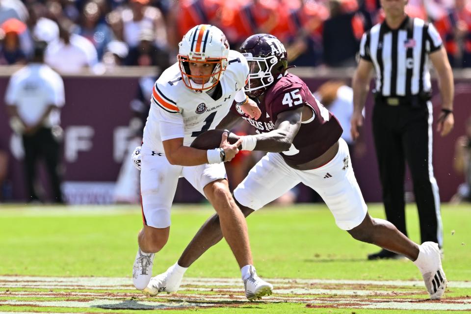Sep 23, 2023; College Station, Texas, USA; Auburn Tigers quarterback Payton Thorne (1) runs the ball on a quarterback keeper as Texas A&M Aggies linebacker Edgerrin Cooper (45) attempts a tackle during the second quarter at Kyle Field. Mandatory Credit: Maria Lysaker-USA TODAY Sports