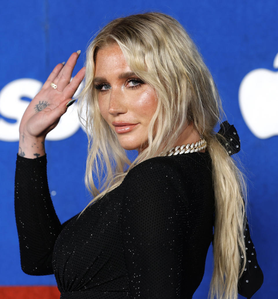 Kesha smiles and waves on the red carpet