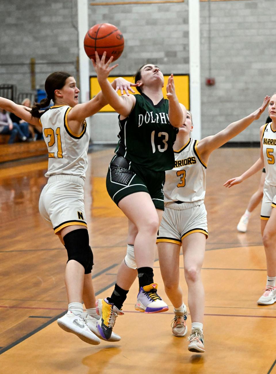 Savannah Azoff of D-Y goes in for a layup between Gabby Foster (21) and Jordyn Streitmatter of Nauset on Friday in North Eastham.
