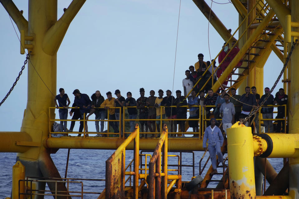 Migrants stand on a petroleum platform in the sea as they wait to be rescued by the Spanish NGO Open Arms lifeguards during a rescue operation in the international waters zone near Tunisia, Mediterranean sea, Saturday, Sept. 17, 2022. Fifty-nine migrants from Syria, Egypt, Sudan and Eritrea, 10 of them minors, were rescued by NGO Open Arms crew members. (AP Photo/Petros Karadjias)