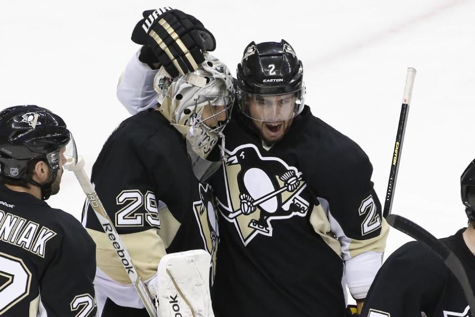 Pittsburgh Penguins defenseman Matt Niskanen (2) celebrates with goalie Marc-Andre Fleury (29) after a 3-1 win over the Columbus Blue Jackets in Game 5 of a first-round NHL playoff hockey series in Pittsburgh, Saturday, April 26, 2014. (AP Photo/Gene J. Puskar)