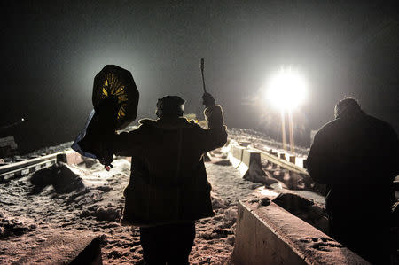 A man holds up a traditional drum during a confrontation between veterans and police on Backwater bridge during a protest against plans to pass the Dakota Access pipeline near the Standing Rock Indian Reservation, near Cannon Ball, North Dakota, U.S., December 1, 2016. REUTERS/Stephanie Keith