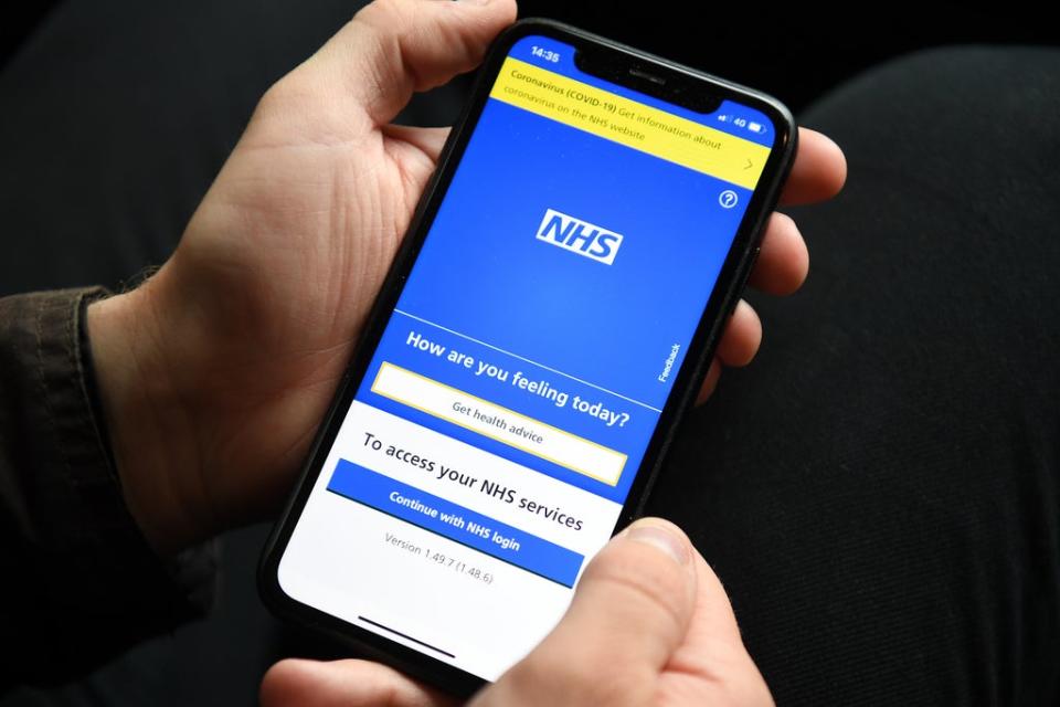 A person holding a mobile phone displaying the NHS app (Kirsty O’Connor/PA) (PA Wire)