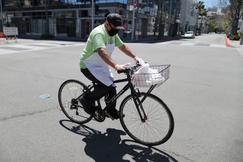 A food delivery driver cycles on an empty road as the global outbreak of the coronavirus disease (COVID-19) continues, in Beverly Hills